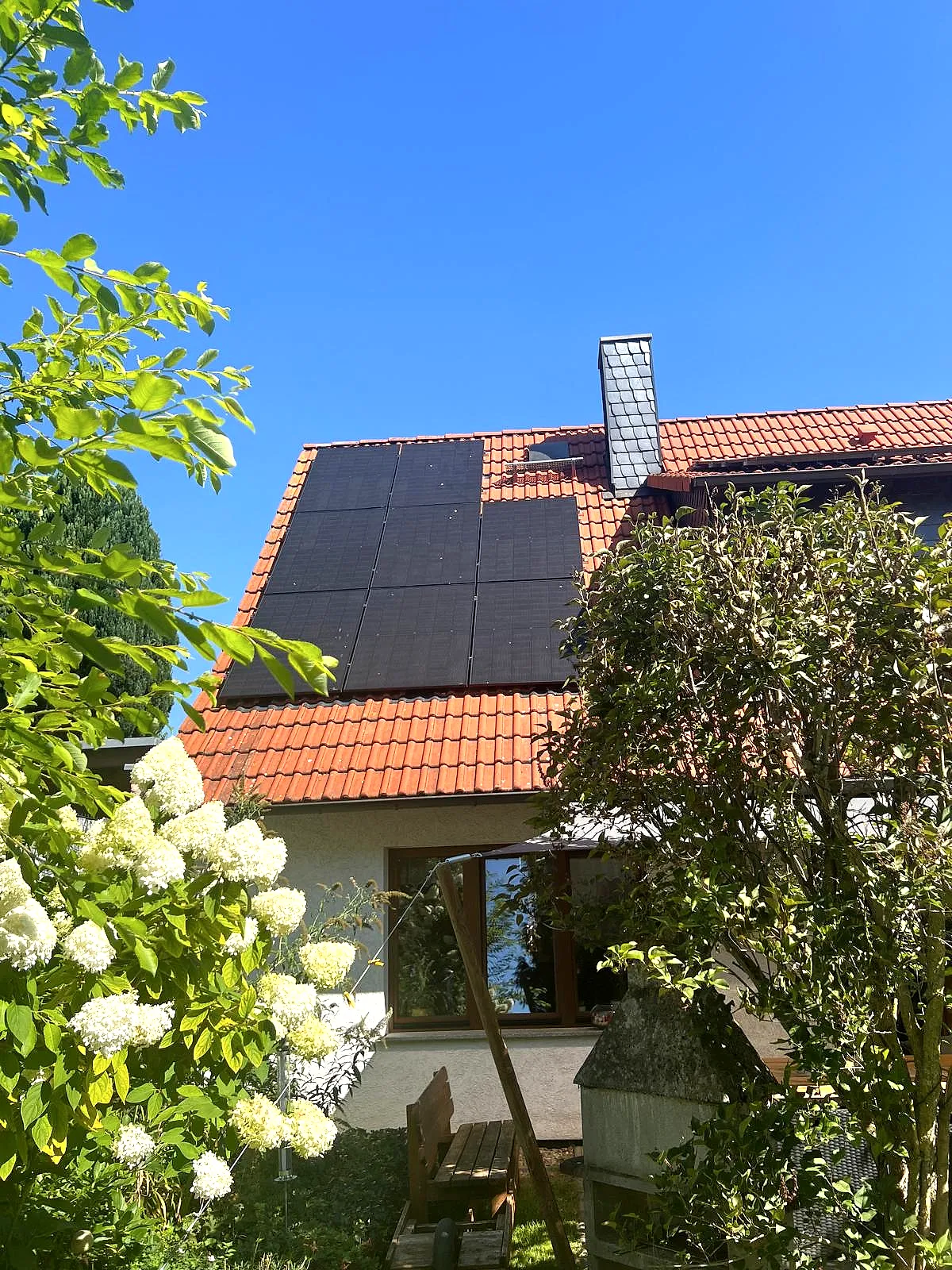 Photovoltaikanlage auf dem roten Ziegeldach eines Wohnhauses