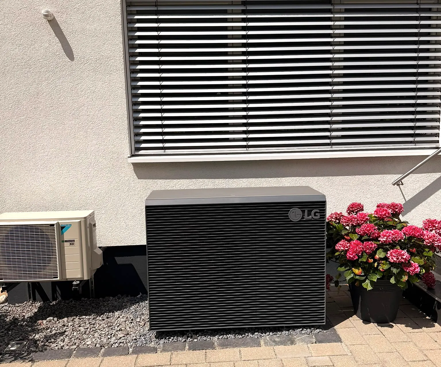 Wärmepumpen-Außeneinheit an der Hauswand eines Wohnhauses